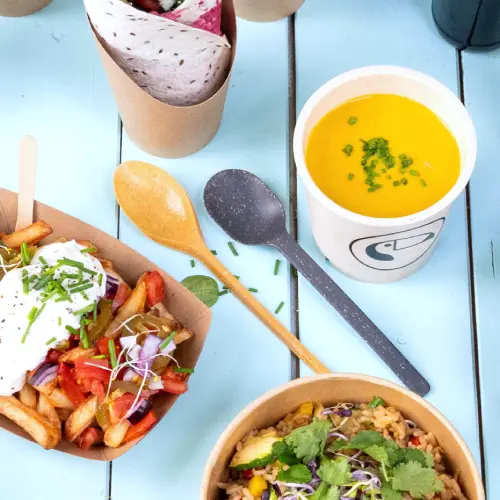L'image présente divers aliments, y compris des frites avec garniture, un bol de riz aux herbes, une soupe dans un verre et des couverts réutilisables sur une surface bleue.